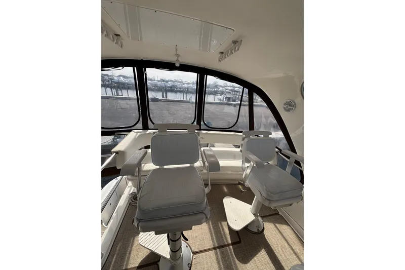 Slide: The Image of Interior view of 2001 Sea Ray 560 Sedan Bridge yacht with helm chairs and panoramic windows. - 14