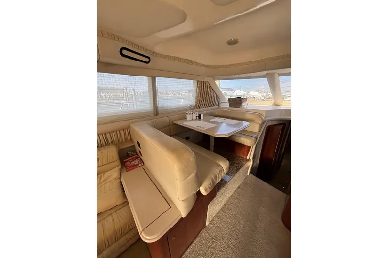 Slide: The Image of Luxurious interior of 2001 Sea Ray 560 Sedan Bridge yacht with plush seating and dining area. - 19