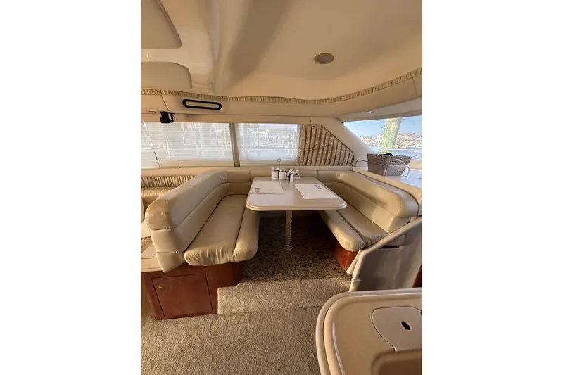 Slide: The Image of Luxurious interior of 2001 Sea Ray 560 Sedan Bridge yacht with plush seating and dining area. - 20