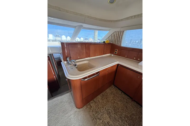 Slide: The Image of 2001 Sea Ray 560 Sedan Bridge yacht interior with wooden cabinetry and sink. - 21