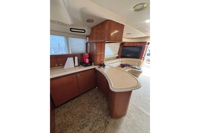 Slide: The Image of Luxurious interior of 2001 Sea Ray 560 Sedan Bridge yacht with modern kitchen and seating area. - 22
