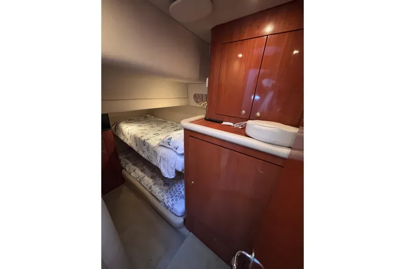 Slide: The Image of 2001 Sea Ray 560 Sedan Bridge cabin with bunk beds and wooden cabinetry. - 26