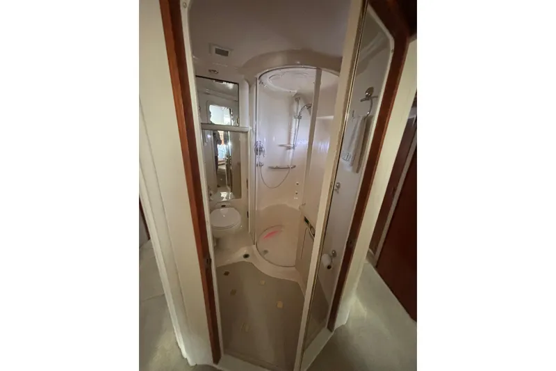 Slide: The Image of Bathroom interior of 2001 Sea Ray 560 Sedan Bridge yacht, featuring shower and toilet. - 32