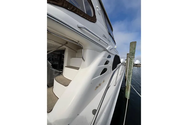 Slide: The Image of 2001 Sea Ray 560 Sedan Bridge yacht docked, showcasing sleek exterior and stairway. - 34