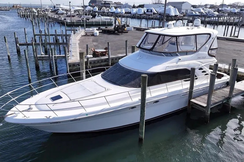 Slide: The Image of 2001 Sea Ray 560 Sedan Bridge yacht docked at marina, showcasing sleek design and spacious deck. - 8