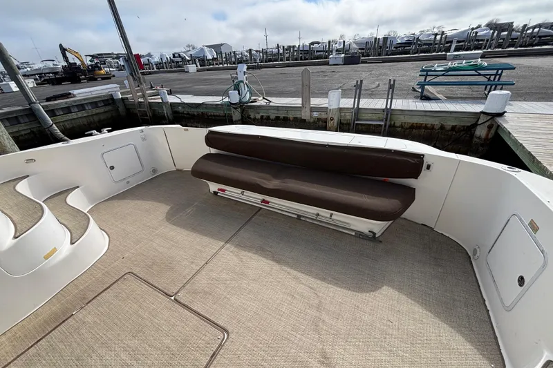 Slide: The Image of 2001 Sea Ray 560 Sedan Bridge yacht deck with seating and dock view. - 9