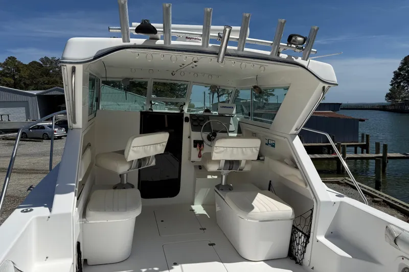 Slide: The Image of 2007 Sport-Craft 302 Sport Fish boat interior with seating and steering wheel, docked by the water. - 5