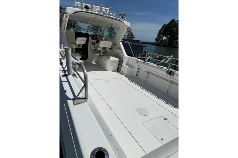 Slide: The Image of 2007 Sport-Craft 302 Sport Fish boat with spacious deck and seating, docked by the water. - 7