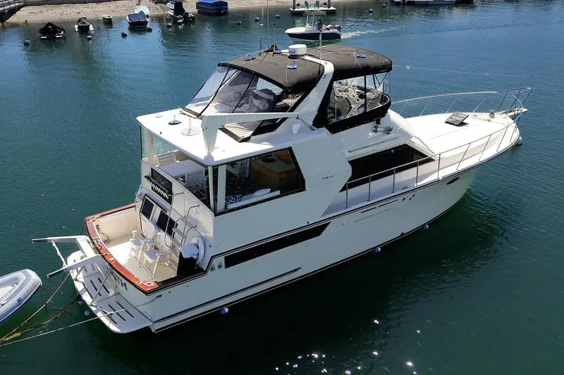 Slide: The Image of 1989 Californian 48 Cockpit Motor Yacht on calm water, showcasing sleek design and spacious deck. - 10