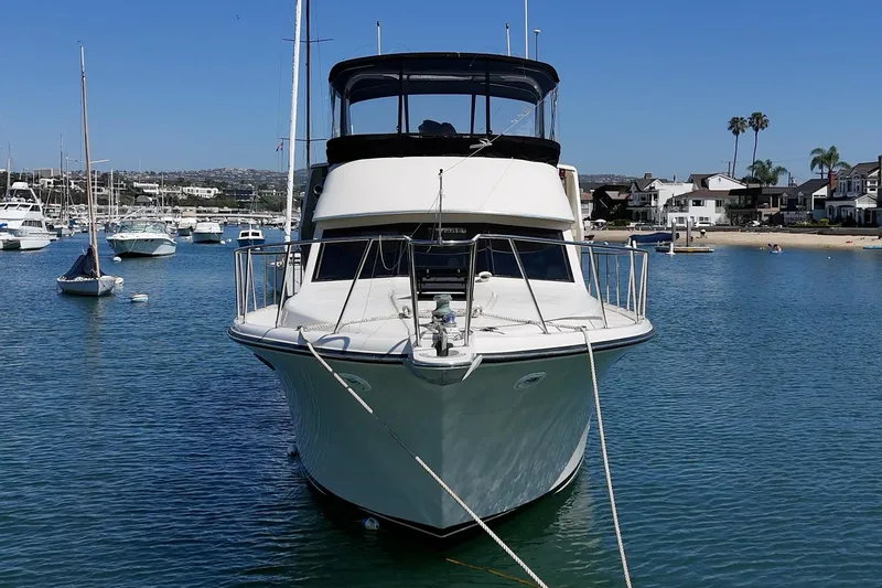 Slide: The Image of 1989 Californian 48 Cockpit Motor Yacht docked in a serene marina setting. - 11
