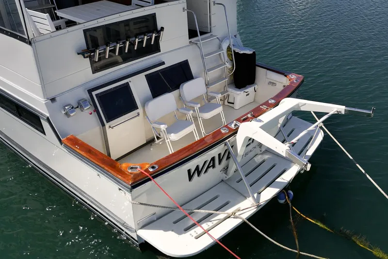 Slide: The Image of 1989 Californian 48 Cockpit Motor Yacht docked, featuring spacious deck and seating area. - 14