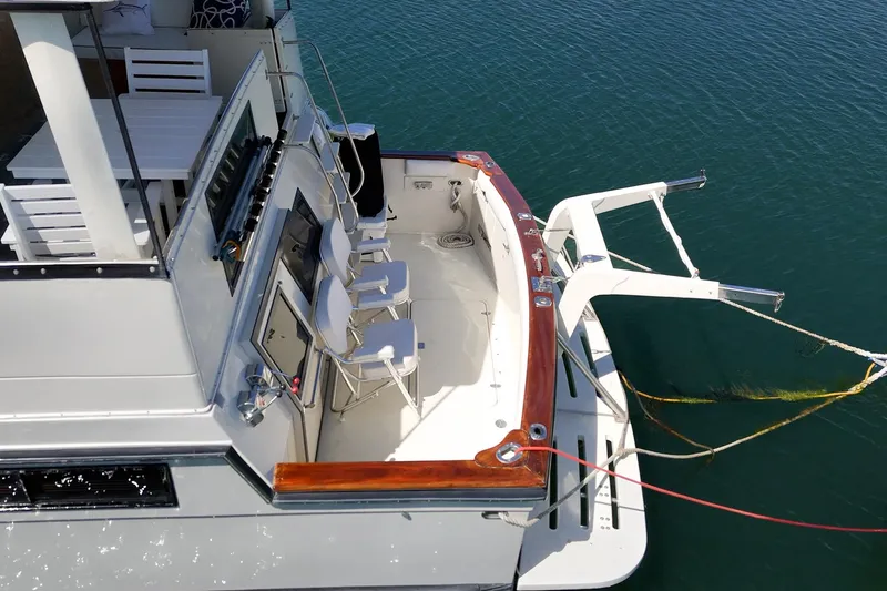 Slide: The Image of 1989 Californian 48 Cockpit Motor Yacht with spacious deck and seating, docked on calm water. - 15