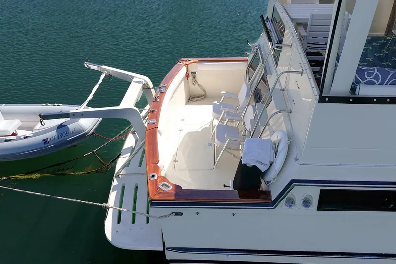 Slide: The Image of 1989 Californian 48 Cockpit Motor Yacht with spacious deck and attached dinghy. - 16