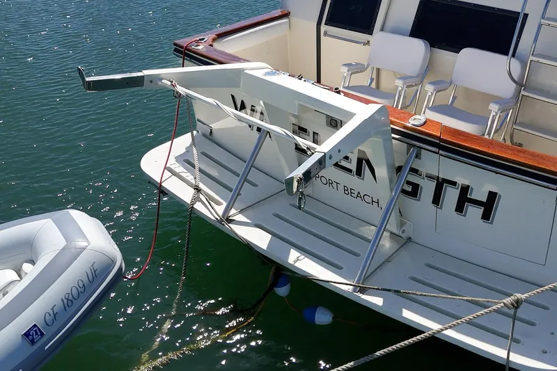 Slide: The Image of 1989 Californian 48 Cockpit Motor Yacht with dinghy, docked in sunny waters. - 18
