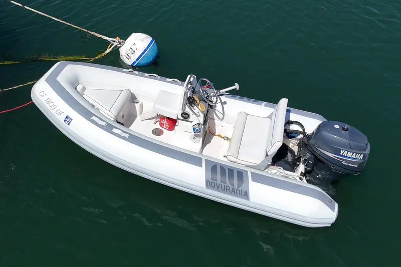 Slide: The Image of Aerial view of a Novurania inflatable boat with Yamaha motor, moored on calm water. - 19