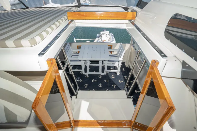 Slide: The Image of 1989 Californian 48 Cockpit Motor Yacht interior with striped seating and nautical-themed carpet. - 21