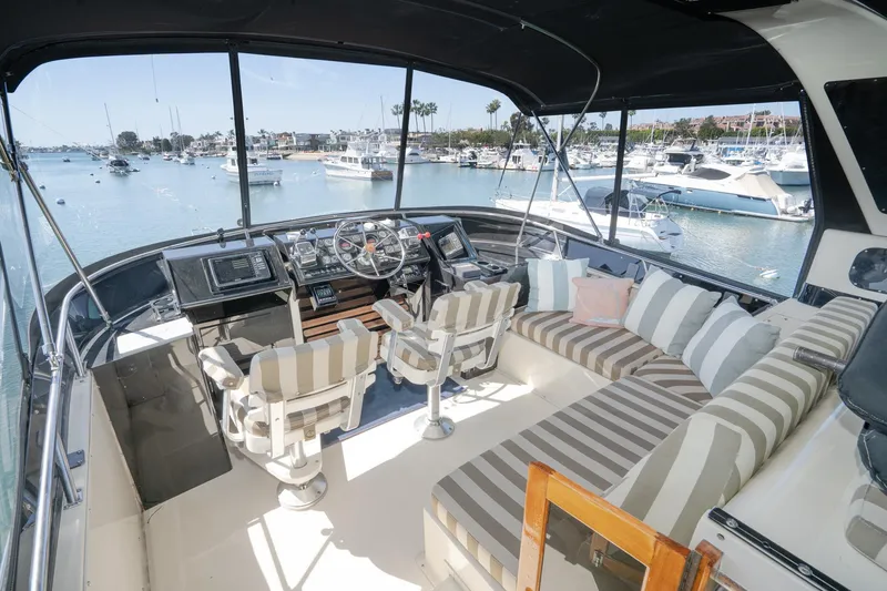 Slide: The Image of 1989 Californian 48 Cockpit Motor Yacht interior with striped seating, overlooking marina. - 22