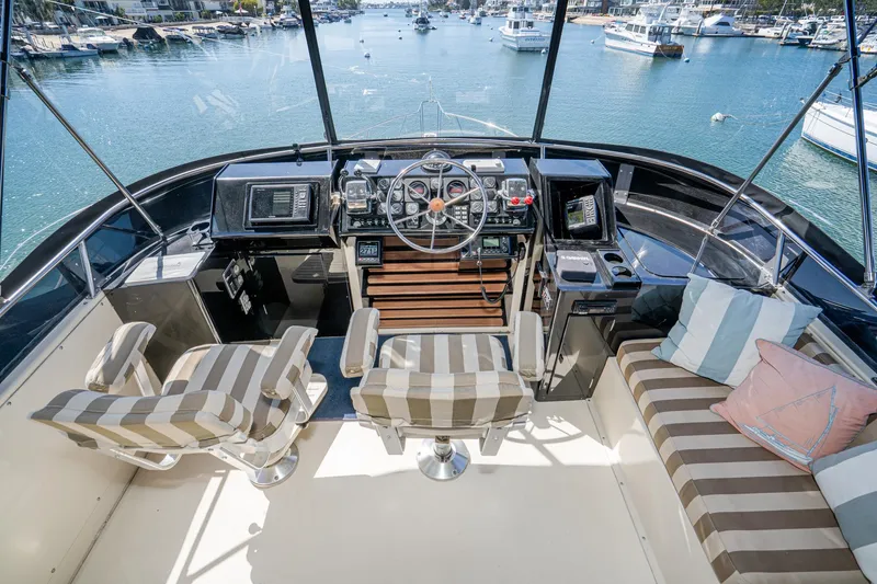 Slide: The Image of Cockpit of 1989 Californian 48 Cockpit Motor Yacht with striped seating and navigational controls. - 23