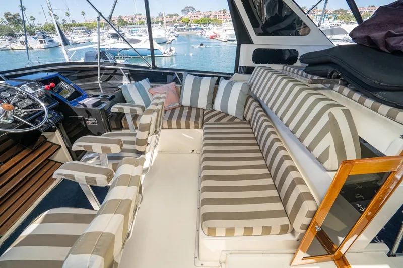 Slide: The Image of Interior of 1989 Californian 48 Cockpit Motor Yacht with striped seating and helm view. - 28