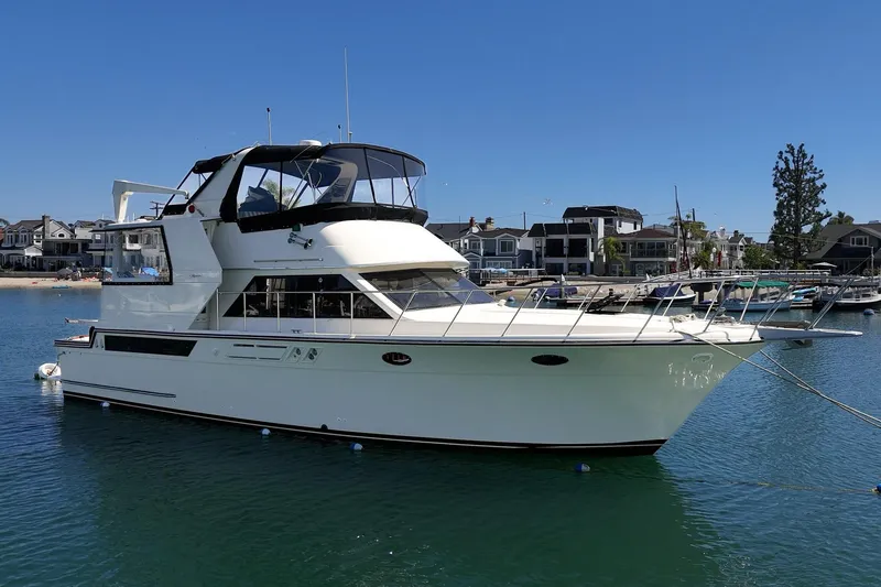 Slide: The Image of 1989 Californian 48 Cockpit Motor Yacht docked in a marina under clear blue skies. - 3