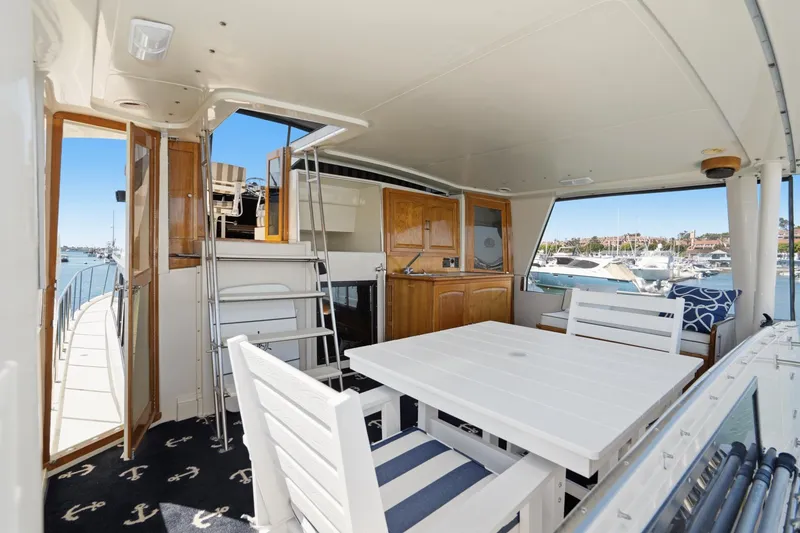 Slide: The Image of 1989 Californian 48 Cockpit Motor Yacht interior with white furniture and marina view. - 32