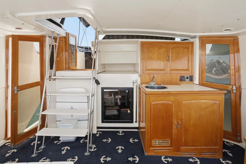 Slide: The Image of 1989 Californian 48 Cockpit Motor Yacht interior with wooden cabinetry and nautical-themed carpet. - 33