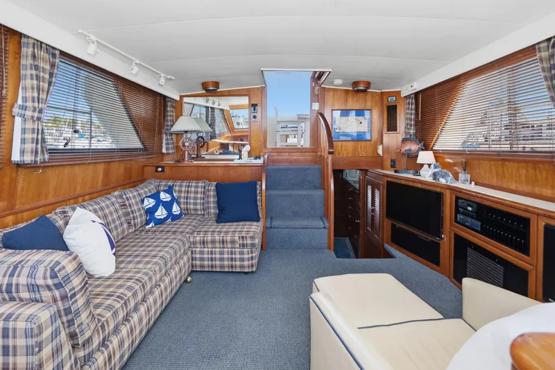Slide: The Image of Luxurious interior of a 1989 Californian 48 Cockpit Motor Yacht with plaid seating and wood accents. - 35