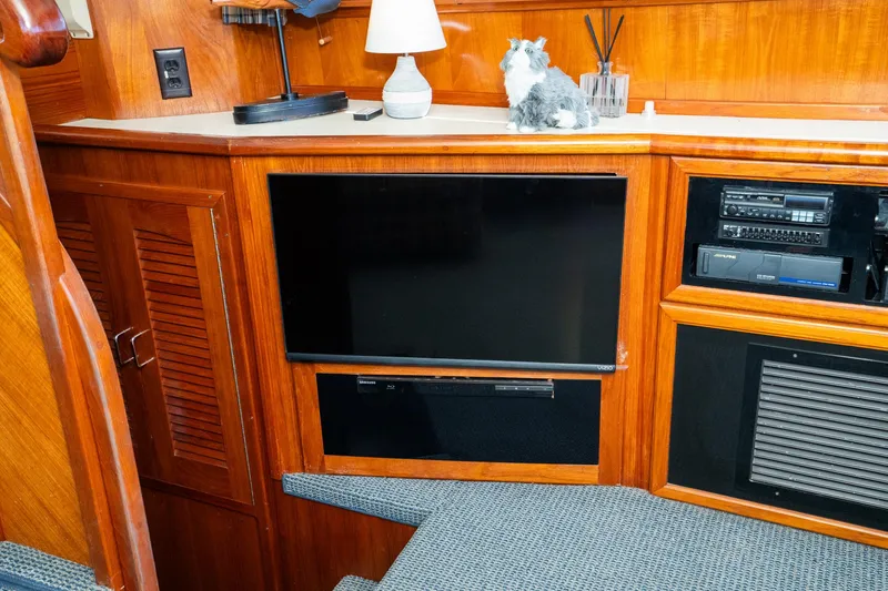 Slide: The Image of 1989 Californian 48 Cockpit Motor Yacht interior with TV, audio system, and wooden cabinetry. - 38