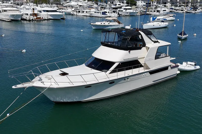 Slide: The Image of 1989 Californian 48 Cockpit Motor Yacht docked in a marina, surrounded by other boats. - 4