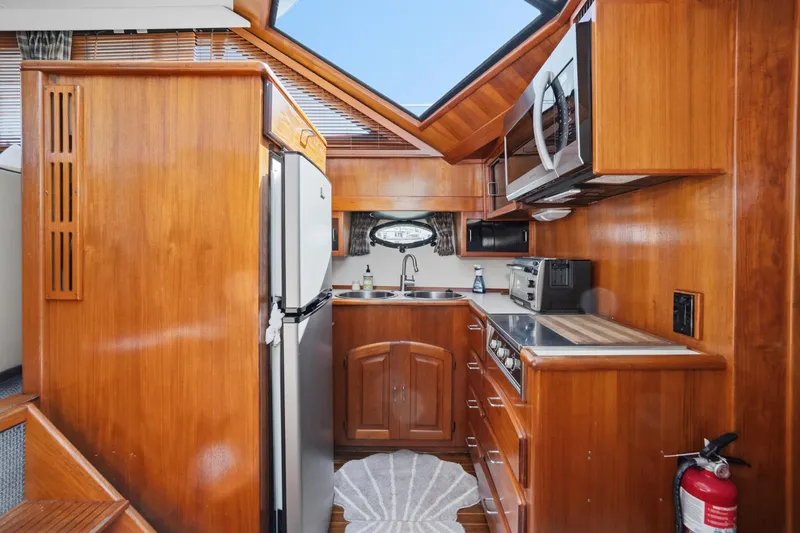 Slide: The Image of 1989 Californian 48 Cockpit Motor Yacht kitchen with wood cabinetry, stainless appliances, and skylight. - 41
