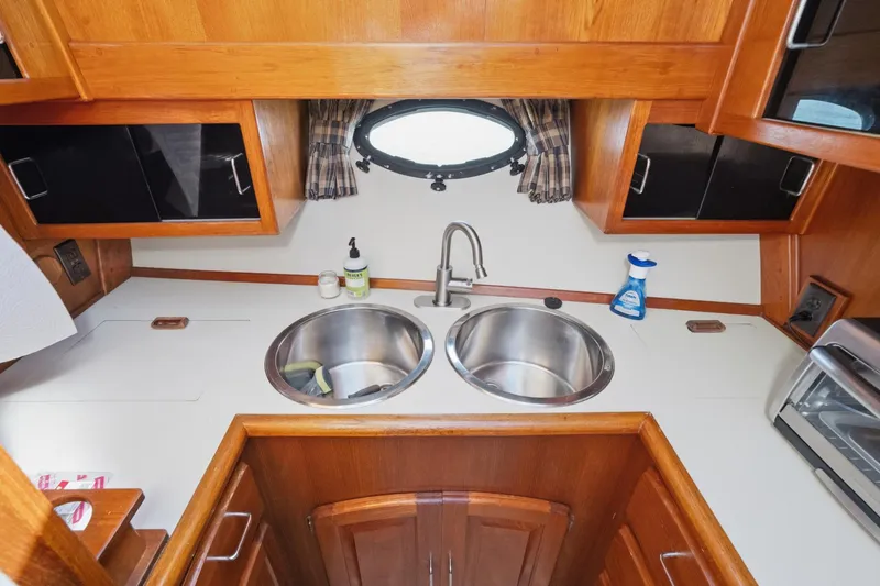 Slide: The Image of 1989 Californian 48 Cockpit Motor Yacht kitchen with dual sinks and wooden cabinetry. - 42