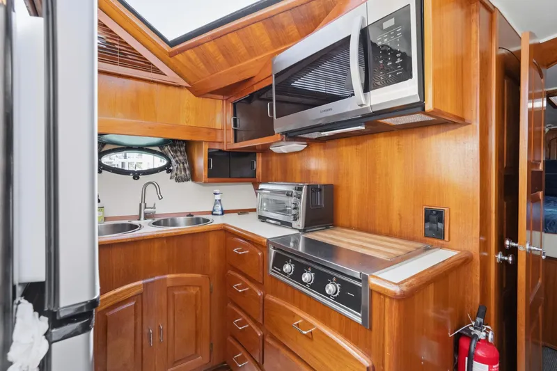 Slide: The Image of 1989 Californian 48 Cockpit Motor Yacht kitchen with wood cabinetry, microwave, and stove. - 43
