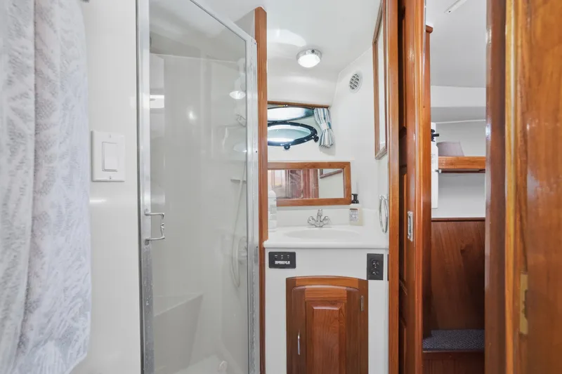 Slide: The Image of Bathroom interior of 1989 Californian 48 Cockpit Motor Yacht with shower and wooden cabinetry. - 48