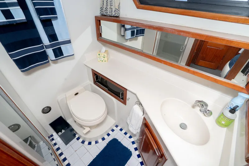 Slide: The Image of Bathroom interior of 1989 Californian 48 Cockpit Motor Yacht with sink, toilet, and mirror. - 54