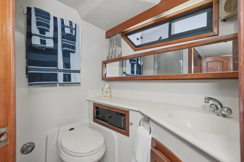 Slide: The Image of Bathroom interior of 1989 Californian 48 Cockpit Motor Yacht with towels and mirror. - 55