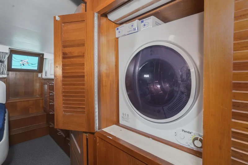 Slide: The Image of Laundry area inside 1989 Californian 48 Cockpit Motor Yacht with wooden cabinetry. - 57