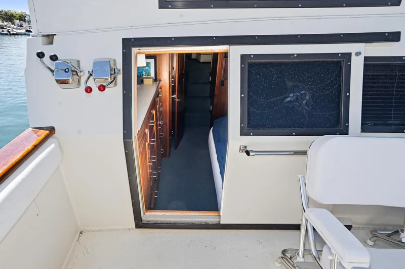 Slide: The Image of 1989 Californian 48 Cockpit Motor Yacht interior view with open cabin door and seating. - 59