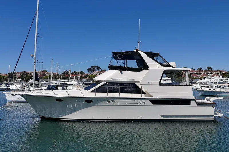 Slide: The Image of 1989 Californian 48 Cockpit Motor Yacht docked in a marina under clear blue skies. - 6