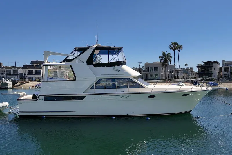 Slide: The Image of 1989 Californian 48 Cockpit Motor Yacht docked in a sunny marina setting. - 7