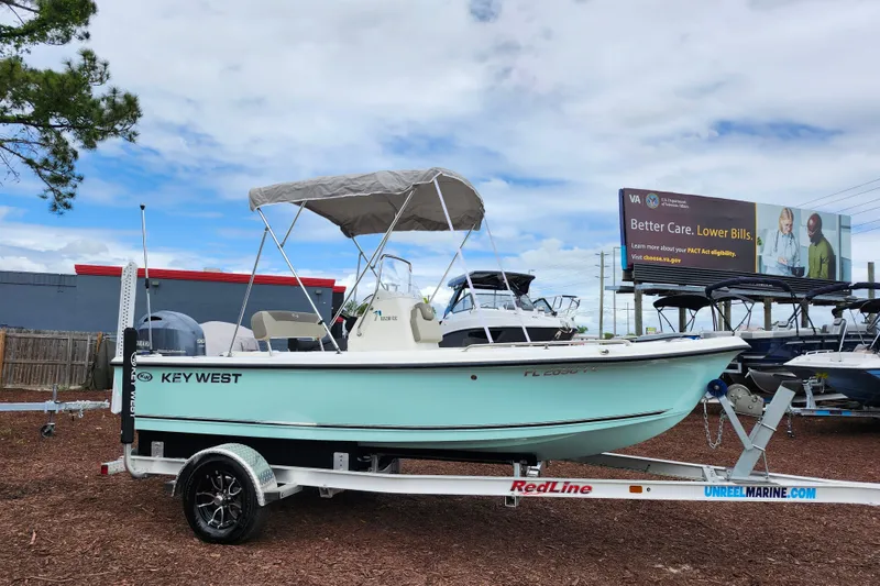 The Image of 2024 Key West 1720 Center Console boat on trailer, displayed outdoors under cloudy sky. - 1