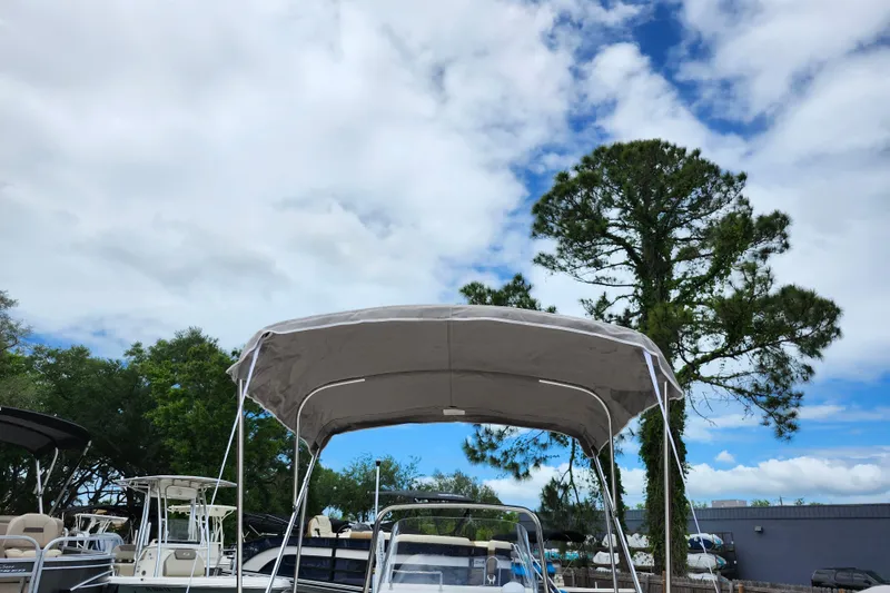 Slide: The Image of 2024 Key West 1720 Center Console boat with canopy, set against a vibrant sky and trees. - 12