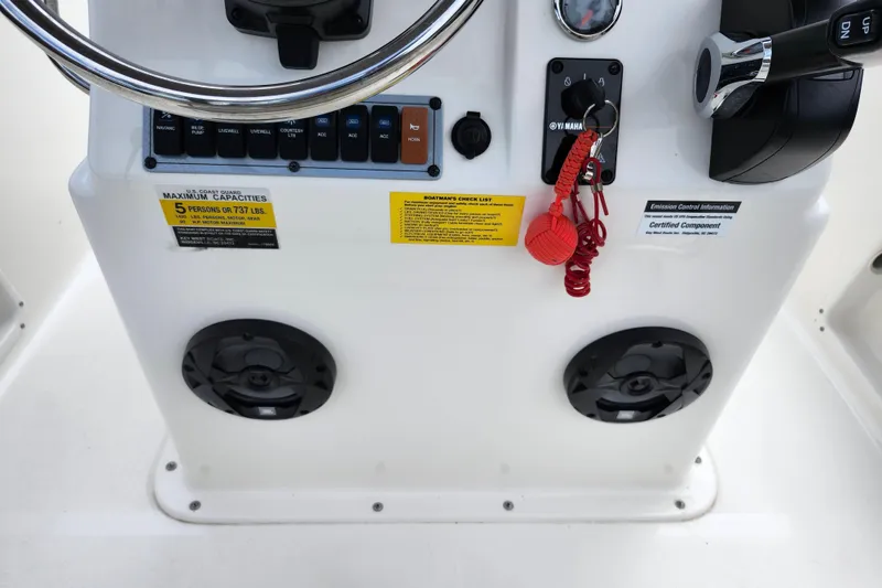 Slide: The Image of 2024 Key West 1720 Center Console dashboard with controls, switches, and safety labels. - 32