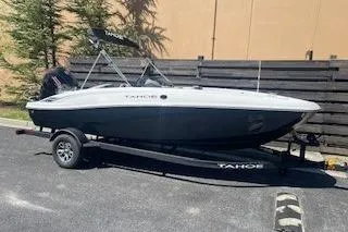 Slide: The Image of 2026 Tahoe T18 boat on trailer, parked outdoors, side view. - 68