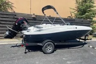 Slide: The Image of 2026 Tahoe T18 boat on trailer, parked outdoors, featuring sleek design and modern outboard motor. - 69