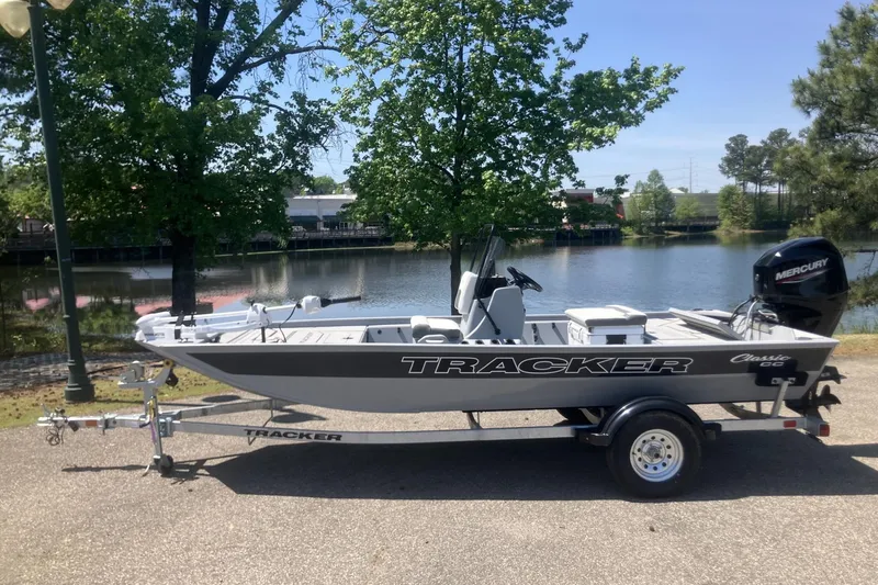 The Image of 2026 Tracker Bass Tracker Classic CC boat on trailer by a lake. - 0