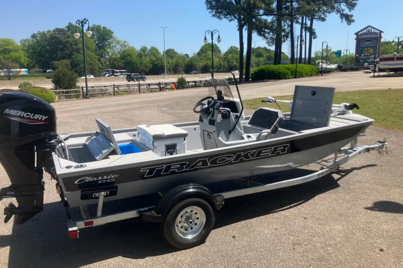 Slide: The Image of 2026 Tracker Bass Tracker Classic CC boat with Mercury engine on trailer, parked outdoors. - 6