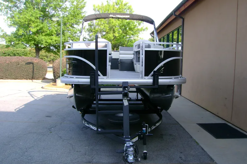 Slide: The Image of 2026 Sun Tracker Fishin' Barge 20 DLX pontoon boat on trailer, parked outdoors. - 3