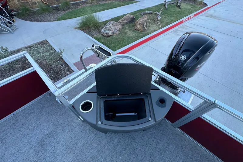 Slide: The Image of 2026 Sun Tracker Bass Buggy 18 DLX boat with open storage compartment and Mercury outboard motor. - 17
