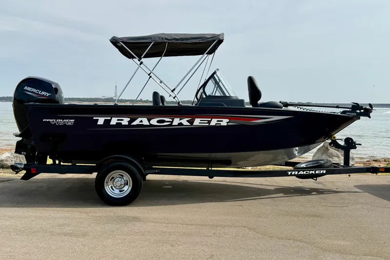 The Image of 2026 Tracker Pro Guide V-175 WT boat with Mercury engine on trailer by the water. - 0