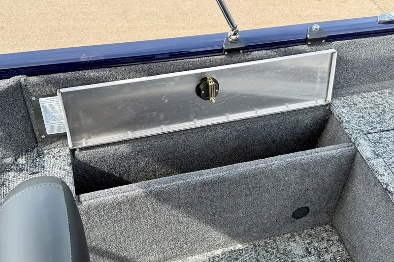 Slide: The Image of 2026 Tracker Pro Guide V-175 WT boat interior storage compartment with gray carpeting. - 19